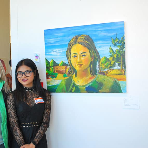 Roosevelt High School artist Paw with her painting in Around the Corner multi-high school art exhibition 2017